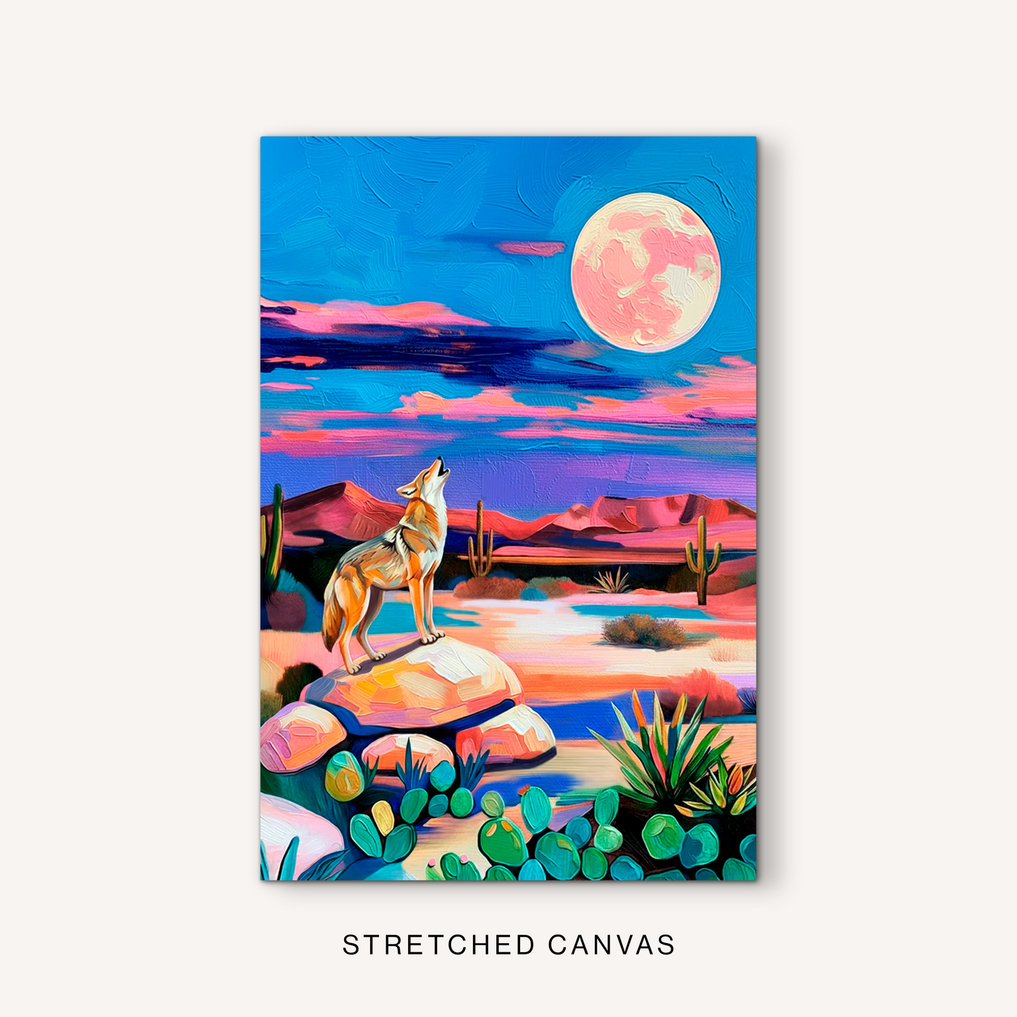 Colorful desert moon canvas art with a howling coyote, cactus plants, vivid blue sky, pink clouds, and western wildlife decor style.