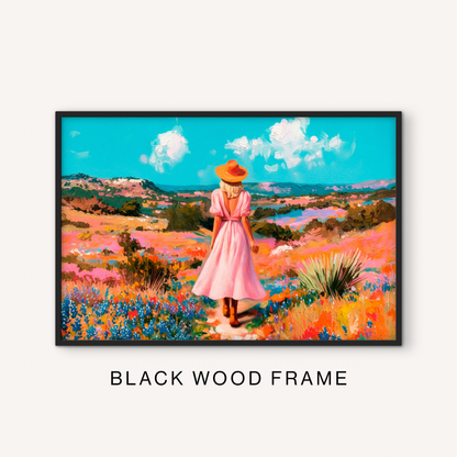Bold western landscape print in a black frame featuring a cowgirl walking through a colorful wildflower meadow with rolling ranch hills.