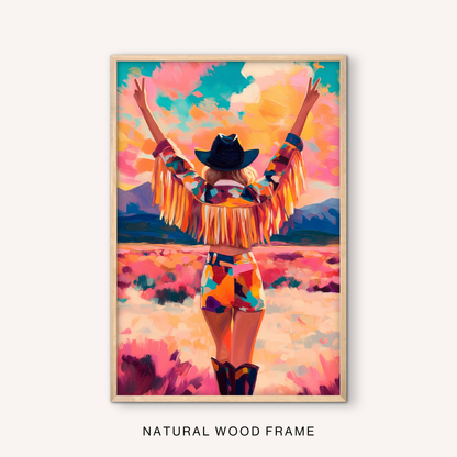Feminine western wall art in a natural wood frame with a cowgirl in a colorful fringe jacket, pink desert field, and boho ranch style.