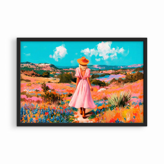 Framed western landscape print in a black frame featuring a woman walking through a colorful field of wildflowers