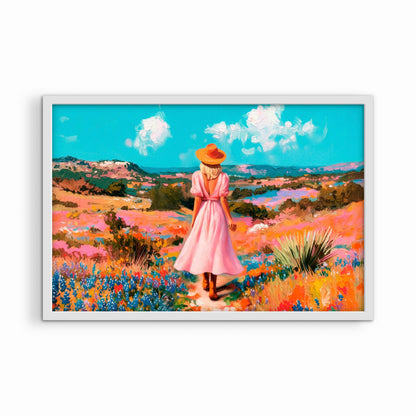 Colorful western wall art in a white frame featuring a woman in a pink dress walking through a vibrant wildflower landscape